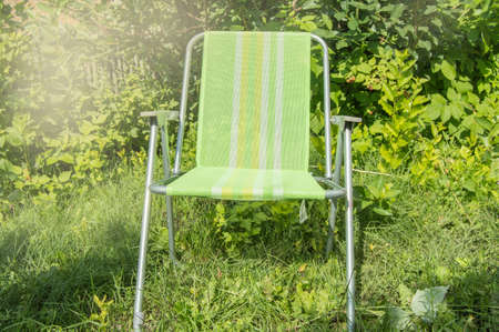 One Empty Folding Garden Chair For Relaxing Stands On The Green