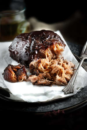 grilled pork: Pulled pork rib roast smothered in BBQ sauce and ready to eat against a rustic background. Concept image for your restaurant or bistro menu cover design. Kho ảnh