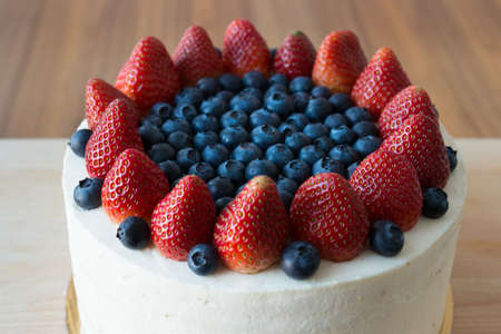 ケーキは手作り ブルーベリーやイチゴで飾られました 木製のスタンドにケーキ の写真素材 画像素材 Image