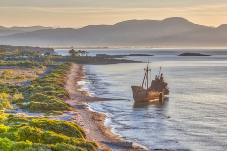 Rusty shipwreck dimitrios in early morning light on peloponnese coast of greece