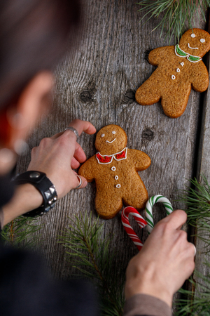 a girl is decorating a table for christmas gingerbread men ginger biscuits and lollipops - Christmas Gingerbread Men Decorations a girl is decorating a table for christmas gingerbread men ginger biscuits and lollipops - Christmas Gingerbread Men Decorations