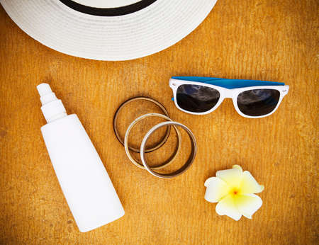 Sun flower: Fashionable clothes sunglasses, stylish bracelets, hat, cream for beach holiday. Top view. Summer vacation concept. Lizenzfreie Bilder