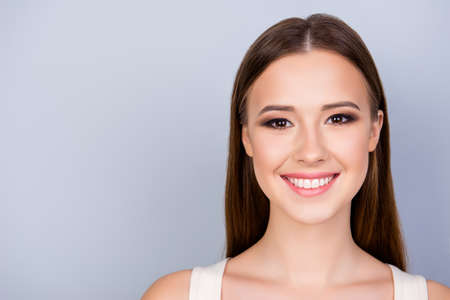 Cerrar una foto recortada de la joven y encantadora dama encantadora en el fondo azul claro puro, tiene una sonrisa dentuda, vistiendo una camiseta blanca informal Foto de archivo - 85642432