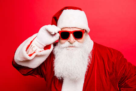 Cool funny playful naughty tourist santa grandfather, fooling around, holding his trendy specs, so confident Stock Photo