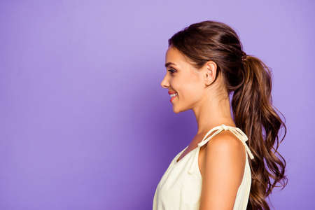 Close-up profile side view portrait of nice adorable well-groomed attractive stunning lovable fascinating magnificent cheerful cheery wavy-haired girl isolated over violet background.