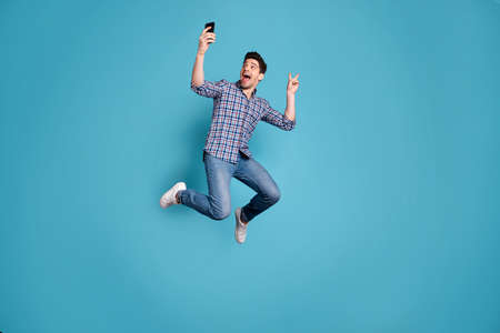 Full length body size view photo of amazed crazy funky youth make photo v-sign free time weekend holidays dream dreamy wear checked shirt jeans legs sneakers isolated blue background