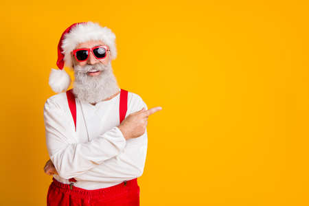 2020 christmas resolution discounts. funny funky grey hair santa claus in red hat point index finger indicate x-mas time sales isolated over yellow color background