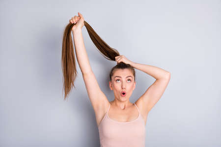 Close-up portrait of her she nice attractive lovely cute cheerful funky brown-haired girl making ponytail medicine recovery solution isolated on light gray pastel color background