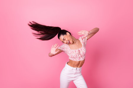 Portrait of gorgeous excited positive lady flying hairdo have fun dancing isolated on pink color background Banco de Imagens