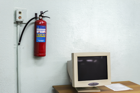 old computer and a fire extinguisher on the wall in the classroom