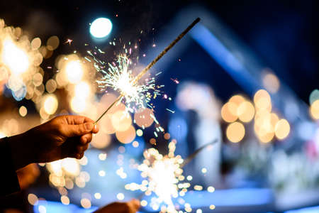 Man hand holding a burning sparkler. bengal fire