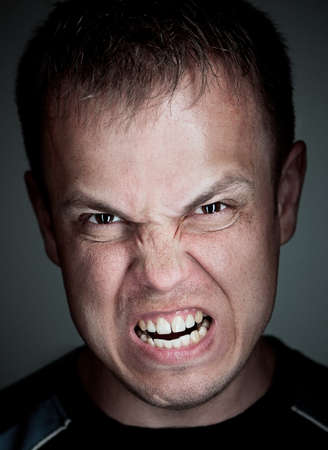 Angry caucasian man. close-up portrait on grey background.