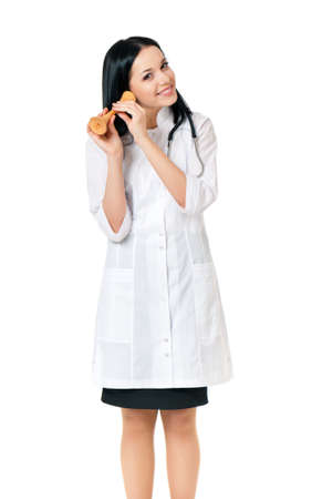 赤ちゃんの心音を聴くための木製聴診器を保持している女性の医者が 白い背景の上分離 の写真素材 画像素材 Image