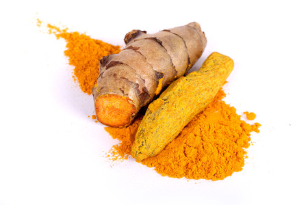 Turmeric powder with fresh turmeric root in white Stock Photo