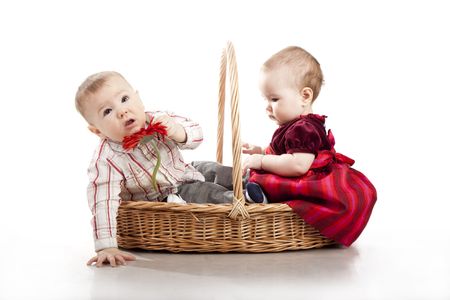 baby boy and baby girl playing together in basket