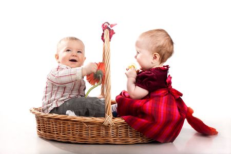 baby boy and baby girl playing together in basket