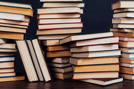 Many stacks of educational books to teach in the library of the house on a black background
