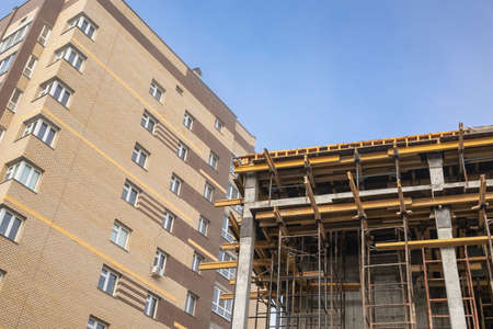 Scaffolding on the construction site, bottom view. the frame of the facade of a building under construction in close-up. the concept of growth and development of the city's infrastructure. Banco de Imagens