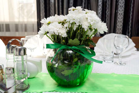 Bouquet Of White Chrysanthemums In Round Glass Vase With Green