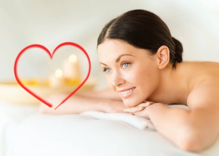 Massage: здоровье и красота, курорт и концепция релаксации - улыбается женщина в спа-салон, лежа на массажном столе