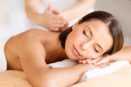 Massage: здоровье, красота, курорт и концепция релаксации - красивая женщина с закрытыми глазами в спа-салоне, получая массаж Фото со стока