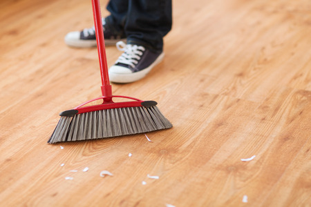 Cleaning and home concept close up of male brooming wooden floor Imagens