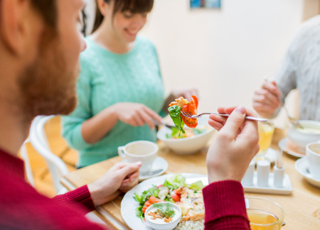 People leisure and food concept close up friends having dinner and eating at restaurant Stock fotó