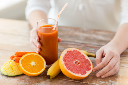 a carrot: ăn uống lành mạnh, thực phẩm, chế độ ăn kiêng và người khái niệm - đóng lên người phụ nữ tay với trái cây và nước trái cây tươi ngồi tại bàn Kho ảnh