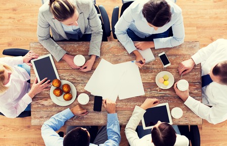 Geschäft, Leute, Bruch und Teamarbeitskonzept - nah oben von der kreativen Teambesprechung und von trinkendem Kaffee mit Muffins während des Mittagessens im Büro