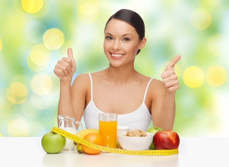 concept de personnes, de geste et de régime-femme asiatique heureuse avec des aliments sains montrant pouce en l'air sur fond de lumières vertes Photo