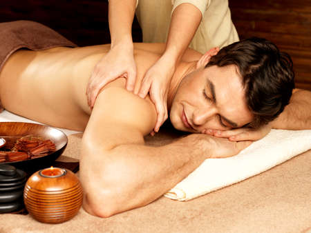 Massage: Массажист делает массаж на человека в спа-салоне. Салоны красоты концепции. Фото со стока