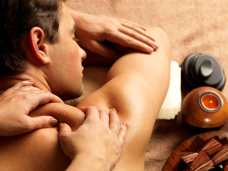 Massage: Массажист делает массаж на человека в спа-салоне. Салоны красоты концепции. Фото со стока