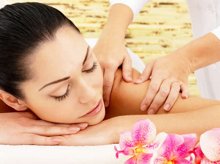 Massage: Молодая женщина на спа массаж плеча в салоне красоты. Фото со стока