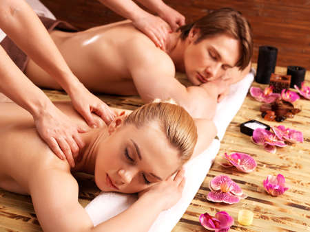 Massage: Привлекательные пара, лежа в спа-салон, наслаждаясь глубокие ткани массаж спины вместе.