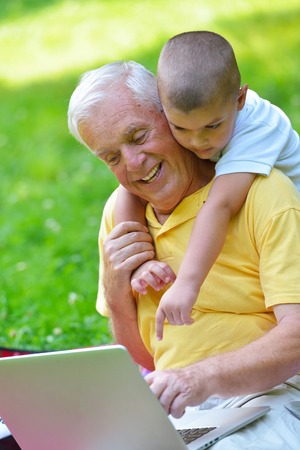 32191566-feliz-abuelo-de-edad-superior-y-el-ni%C3%B1o-en-el-parque-usando-el-ordenador-port%C3%A1til.jpg