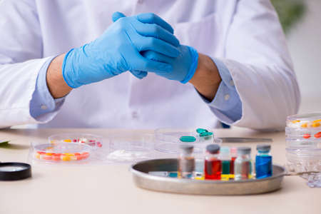 Young Male Lab Assistant In Drug Synthesis Concept