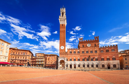 Siena, włochy. słoneczny letni malowniczy piazza del campo, palazzo pubblico i wieża mangia (torre del mangia) w sienie. architektura i zabytki toskanii. Zdjęcie Seryjne