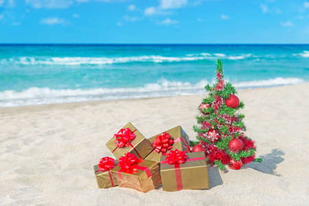 christmas tree and golden gift with big red bow on the sea sandy beach christmas - Beach Christmas Tree christmas tree and golden gift with big red bow on the sea sandy beach christmas - Beach Christmas Tree