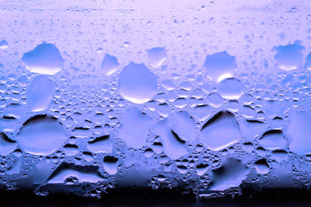 Condensation, vapor, rain, water drops of various sizes on a glass surface. pink tone color. Stock Photo