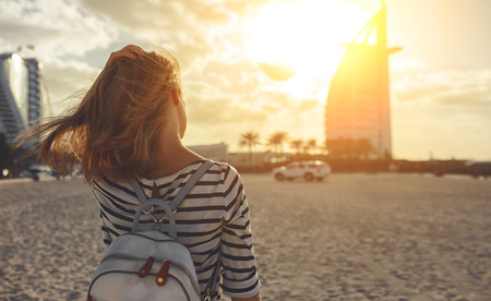 happy young woman enjoying freedom with open hands on sea at Burj Al Arab, hotel in Dubai United Arab Emirates UAE, January 2018
 - 93867684