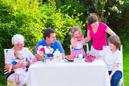 幸せな大家族 若い母親と子供 十代の年齢の息子 かわいいよちよち歩きの娘と小さな赤ちゃんの父の祖母の庭のフルーツ スイカ イチゴを食べるとランチを楽しんでください の写真素材 画像素材 Image 幸せな大家族 若い母親と子供 十代の年齢の息子 かわいいよちよち歩きの娘と小さな赤ちゃんの父の祖母の庭のフルーツ スイカ イチゴを食べるとランチを楽しんでください の写真素材 画像素材 Image