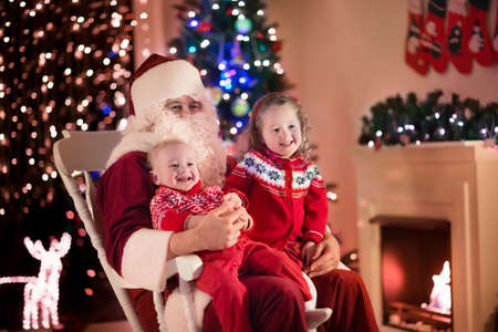 santa claus and children opening presents at fireplace kids and father in santa costume and - Santa Claus Presents santa claus and children opening presents at fireplace kids and father in santa costume and - Santa Claus Presents