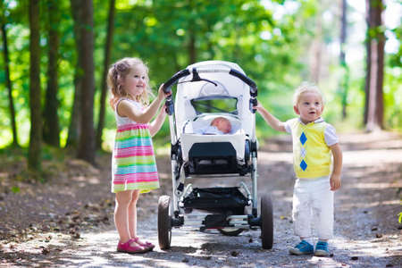 Bebé recién nacido durmiendo en cochecito blanco en una caminata en el parque de verano. Nueva niño nacido siesta al aire libre en un día soleado Bebé recién nacido durmiendo en cochecito blanco en una caminata en el parque de verano. Nueva niño nacido siesta al aire libre en un día soleado