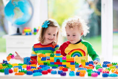 カラフルなおもちゃで遊ぶ子 小さな女の子と教育おもちゃのブロック中おかしい男の子 お子様は デイケアや幼稚園で遊ぶ 子供の部屋を混乱します 幼児は 幼稚園で塔を建てます の写真素材 画像素材 Image
