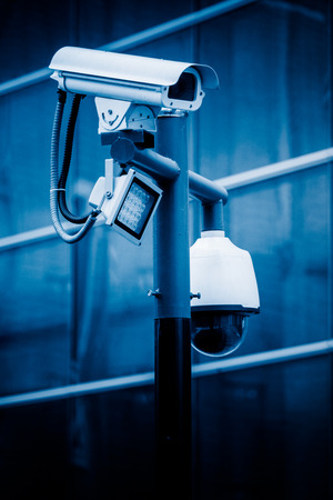 cctv security camera against building in blue tone stock photo