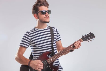 スタジオの背景で傾いて エレキギターを弾きながらポーズをとってロック アーティストの肖像画 の写真素材 画像素材 Image スタジオの背景で傾いて エレキギターを弾きながらポーズをとってロック アーティストの肖像画 の写真素材 画像素材 Image