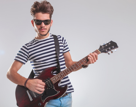 スタジオの背景で傾いて エレキギターを弾きながらポーズをとってロック アーティストの肖像画 の写真素材 画像素材 Image スタジオの背景で傾いて エレキギターを弾きながらポーズをとってロック アーティストの肖像画 の写真素材 画像素材 Image