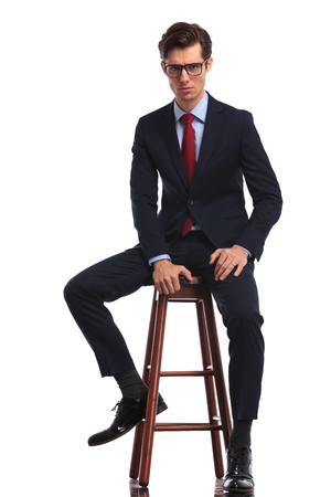 Homme élégant Cool Assis En Studio, Portant Un Jean Et Un Homme élégant Cool Assis En Studio, Portant Un Jean Et Un