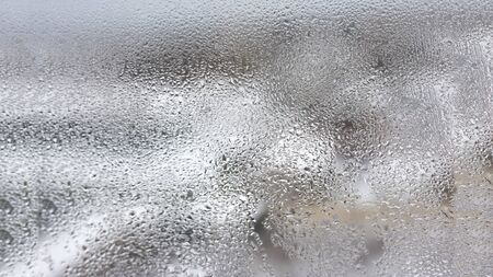 Transparent condensate in the foggy background, water dripping on clear glass. drops of condensation close-up macro. steam on the glass. condenser.