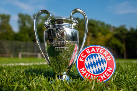 August 30, 2021 Munich, Germany. Fc Bayern Munich Football Emblem And Uefa Champions League Cup On The Green Turf Of The Stadium.